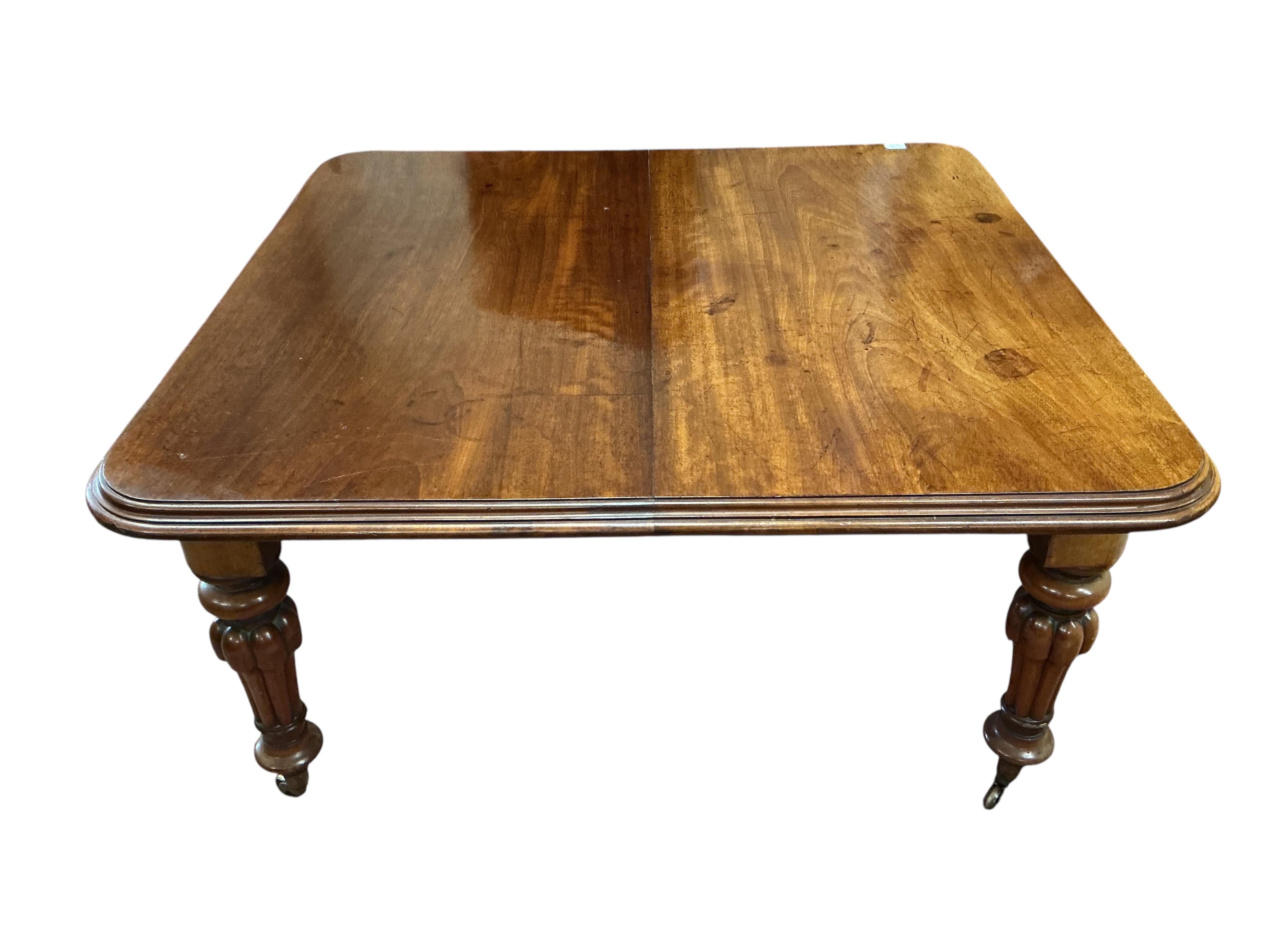 A Victorian mahogany extending dining table, width 285cm extended, three spare leaves